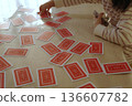 A child playing with a deck of cards he has won 136607782