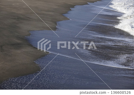 夕陽映照著沙灘和海浪的痕跡。 136608526