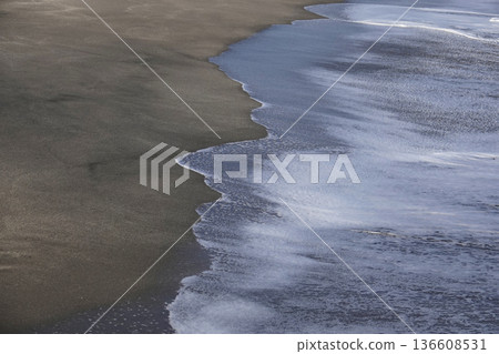 夕陽西下，陽光灑在沙灘和海岸線的漣漪上。 136608531