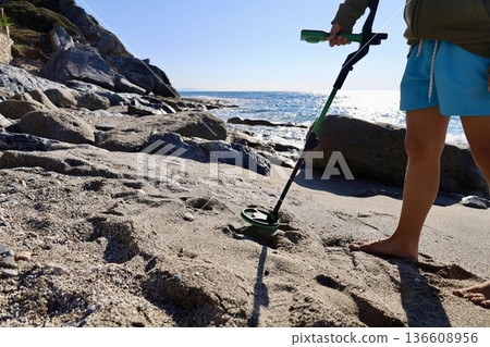 Beach metal detecting. High quality photo 136608956