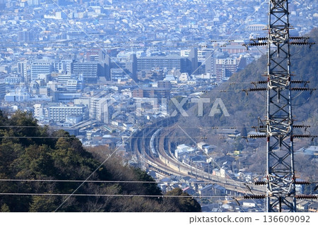 一列火車穿梭於山脈之間，從半山腰的高壓塔上可俯瞰城市景觀。 136609092