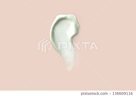 Light green Swatch sampled with a smear of cream. Face skin care, hand care, facial care. Isolated photo beige background 136609116