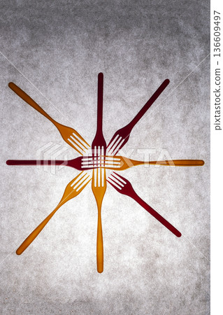 Yellow and red plastic forks on a gray background Yellow and red plastic forks on a gray background 136609497