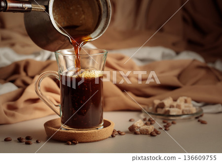 Pour the black coffee into a cup. 136609755