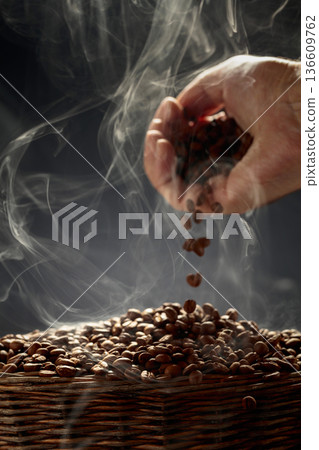 The freshly roasted coffee beans are poured into a basket. 136609762