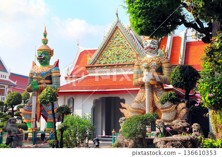Two Colorful Giant Yaksha statues, guarding the entrance of Buddhist Temple of Dawn Wat Arun, sightseeing landmark of Bangkok, Thailand. Topic of summer vacation, relaxing, travel, trip, cruises, tour Two Colorful Giant Yaksha statues, guarding the entrance of Buddhist Temple of Dawn Wat Arun, sightseeing landmark of Bangkok, Thailand. Topic of summer vacation, relaxing, travel, trip, cruises, tour 136610353