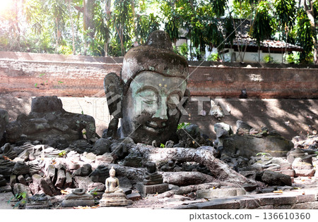 Old Stone Head Buddha and Ancient Buddha statues, Wat Umong temple complex, Chiang Mai. Head of old Buddha statue at Umong Temple, Northern Thailand. Topic of vacation, travel, trip, cruise, tour 136610360