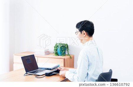 Hands of a man preparing to file his tax return Hands of a man preparing to file his tax return 136610792