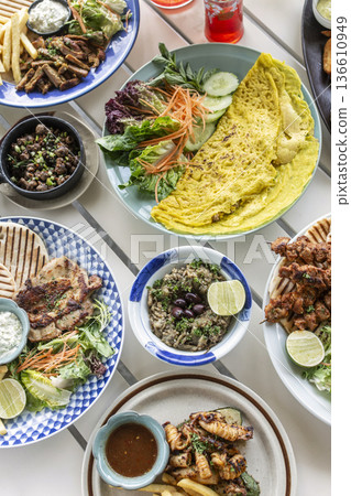 many different mediterranean food dishes on restaurant table in greece 136610949