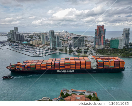 Miami, Florida, USA - January 16, 2025: Aerial view cargo ship entering harbor. Container ship. Cargo ship with container in Miami and tug boat. Freight container loaded on cargo vessel in Miami Miami, Florida, USA - January 16, 2025: Aerial view cargo ship entering harbor. Container ship. Cargo ship with container in Miami and tug boat. Freight container loaded on cargo vessel in Miami 136611085