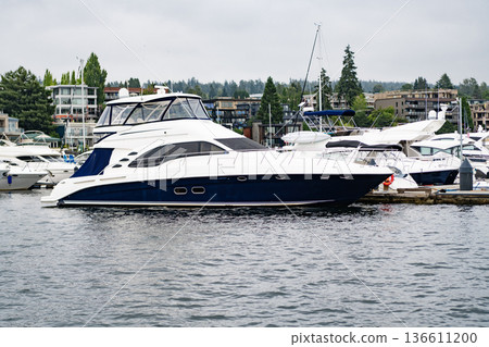Yacht club. Sea vacation on summer. Boating and yachting charter. Summer vacation. Luxury boat in marina. Yacht at sea marina. Luxury boat motor yacht in private marina. Docked vessels. Boat trip 136611200