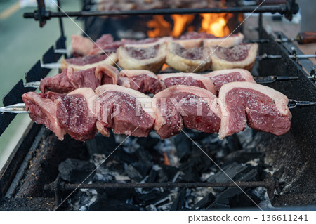 Brazilian BBQ. Family barbecue. Picanha barbecue roasted over hot coals. Beef meat on BBQ grill. Steak rotisserie at steakhouse grill. Street food. Grilled roast beef. Grilled picanha 136611241