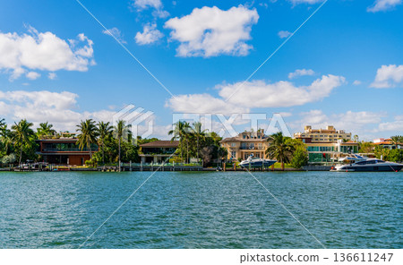 Residential waterfront apartment with boat. Waterfront landscape with house. Vacation in summer. Luxury waterfront hotel building. Summer vacation. Yacht in luxury residential area Residential waterfront apartment with boat. Waterfront landscape with house. Vacation in summer. Luxury waterfront hotel building. Summer vacation. Yacht in luxury residential area 136611247