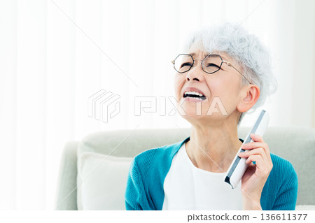Senior woman talking on landline phone Senior woman talking on landline phone 136611377