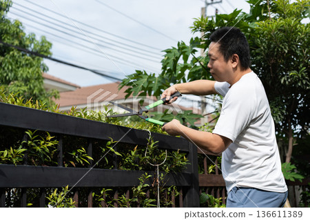 A man takes care of his home by cleaning the floor and trimming the garden. Simple daily routines that reflect pride in a clean and pleasant home. A man takes care of his home by cleaning the floor and trimming the garden. Simple daily routines that reflect pride in a clean and pleasant home. 136611389