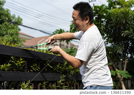 A man takes care of his home by cleaning the floor and trimming the garden. Simple daily routines that reflect pride in a clean and pleasant home. A man takes care of his home by cleaning the floor and trimming the garden. Simple daily routines that reflect pride in a clean and pleasant home. 136611390