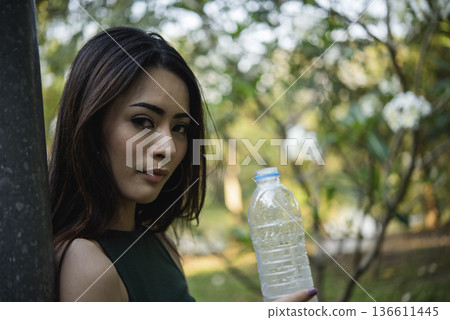 Young Woman Drinking Water bottle outdoor park traveler. Asian female drinking water bottle healthy person happy smile. Happiness Beautiful asian chinese women holding mineral water bottle lifestyle Young Woman Drinking Water bottle outdoor park traveler. Asian female drinking water bottle healthy person happy smile. Happiness Beautiful asian chinese women holding mineral water bottle lifestyle 136611445