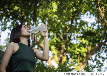 Young Woman Drinking Water bottle outdoor park traveler. Asian female drinking water bottle healthy person happy smile. Happiness Beautiful asian chinese women holding mineral water bottle lifestyle Young Woman Drinking Water bottle outdoor park traveler. Asian female drinking water bottle healthy person happy smile. Happiness Beautiful asian chinese women holding mineral water bottle lifestyle 136611447