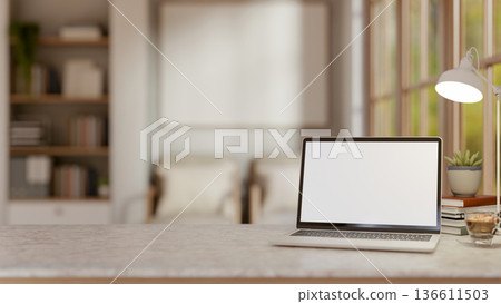 White screen laptop and coffee under lamp on marble table aside window in a living room or library. 136611503