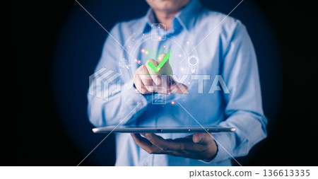 person uses a tablet with a glow green checkmark icon by digital document and symbol representing approve processes,digital workflow,document verification,efficiency,and online authorization. person uses a tablet with a glow green checkmark icon by digital document and symbol representing approve processes,digital workflow,document verification,efficiency,and online authorization. 136613335