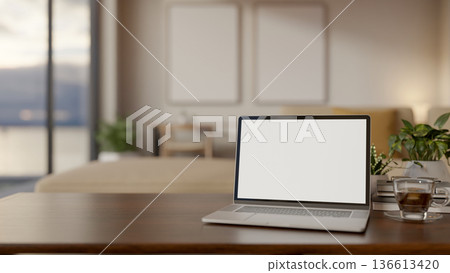 Blank screen laptop with coffee and pot plant on wooden table aside window in living room or office. Blank screen laptop with coffee and pot plant on wooden table aside window in living room or office. 136613420