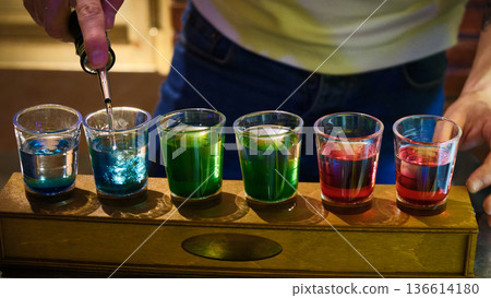 Colorful Shot Glasses with Layered Cocktails on Bar Counter Colorful Shot Glasses with Layered Cocktails on Bar Counter 136614180