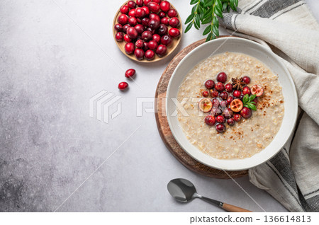 Oatmeal with cranberry, cinnamon and spicy in a plate on a gray concrete background 136614813