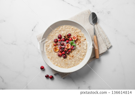 Oatmeal with cranberry, cinnamon and spicy in a plate on a marble background 136614814