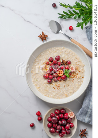 Oatmeal with cranberry, cinnamon and spicy in a plate on a marble background 136614815