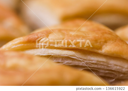 Golden flaky pastry crust close up showcasing delicious texture, perfect for bakery, snack, and food concepts 136615922