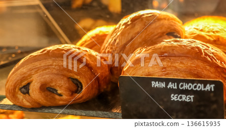 Delicious pain au chocolat pastries for sale in a typical French Parisian bakery display case Delicious pain au chocolat pastries for sale in a typical French Parisian bakery display case 136615935