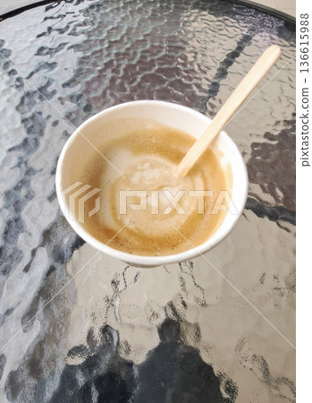 Black coffee cup held in a glass table. Coffee brand presentations, or eco-conscious packaging mockups, organic environment. Black coffee cup held in a glass table. Coffee brand presentations, or eco-conscious packaging mockups, organic environment. 136615988