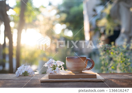 Earthenware vintage brown clay coffee cup and flowers and notebooks Earthenware vintage brown clay coffee cup and flowers and notebooks 136616247