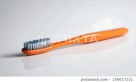 Close-Up of Bright Orange Toothbrush with Blue Bristles on White Surface Close-Up of Bright Orange Toothbrush with Blue Bristles on White Surface 136617231