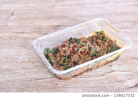 spicy stir fried chop beef meat with chili and basil in clear plastic box for take home on table spicy stir fried chop beef meat with chili and basil in clear plastic box for take home on table 136617332