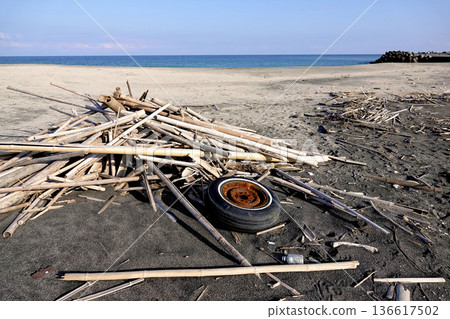 水邊沙灘上堆積浮木和雜物。 水邊沙灘上堆積浮木和雜物。 136617502