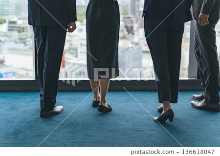 The feet of a group of business people looking out from their office The feet of a group of business people looking out from their office 136618047