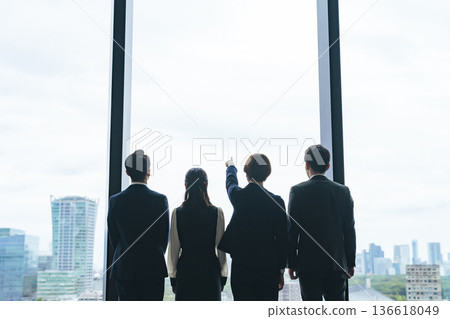 Group of business people looking out from their office Group of business people looking out from their office 136618049