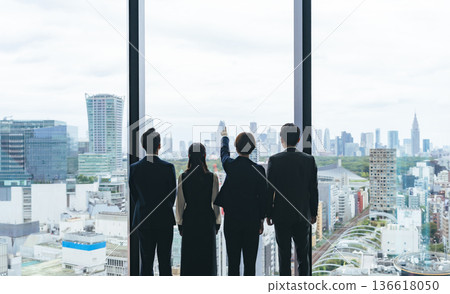 Group of business people looking out from their office Group of business people looking out from their office 136618050