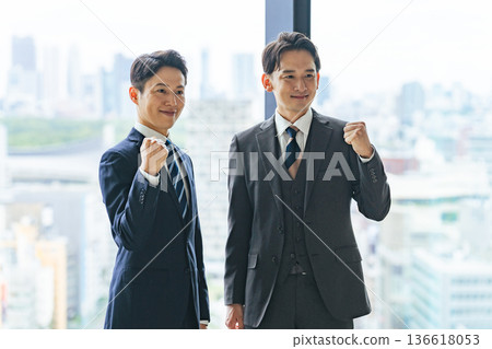 一群商務人士在大廳揮舞著拳頭。 一群商務人士在大廳揮舞著拳頭。 136618053