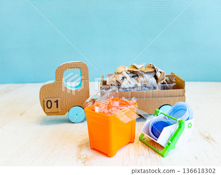 Cardboard toy truck carrying waste with recycling bins on white background Cardboard toy truck carrying waste with recycling bins on white background 136618302