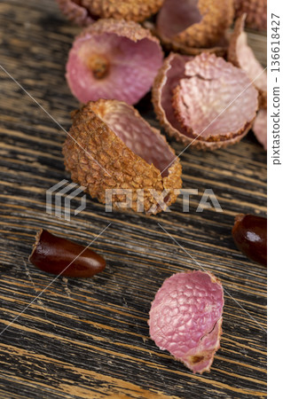 open red lychees cut into pieces on a wooden table, lychee fruits with cut pink tough peel, cooking lychee, close up open red lychees cut into pieces on a wooden table, lychee fruits with cut pink tough peel, cooking lychee, close up 136618427