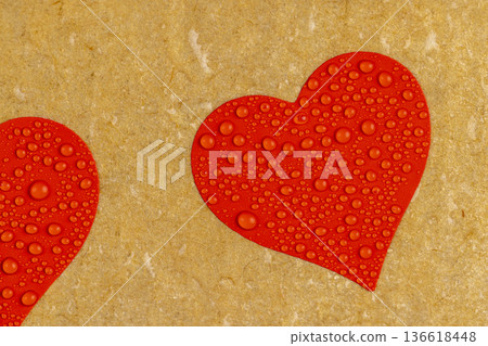 wet hard cardboard for packaging goods and products with red plastic hearts glued on , a piece of corrugated cardboard with red hearts covered with water droplets wet hard cardboard for packaging goods and products with red plastic hearts glued on , a piece of corrugated cardboard with red hearts covered with water droplets 136618448