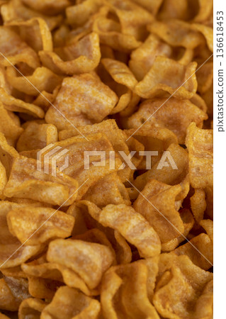 crispy mashed potato chips fried in a large amount of sunflower oil, sprinkled with red hot pepper spices, crispy delicious chips with spices are scattered on the table 136618453