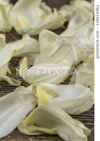 dry ugly tulip flowers and petals are scattered on an old black wooden table, flower details from a bouquet that have wilted and crumbled from long-term storage dry ugly tulip flowers and petals are scattered on an old black wooden table, flower details from a bouquet that have wilted and crumbled from long-term storage 136618461