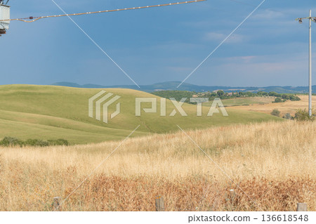 Golden agricultural fields beneath a dramatic sky. Rural landscape, changing weather and natural contrast concept Golden agricultural fields beneath a dramatic sky. Rural landscape, changing weather and natural contrast concept 136618548