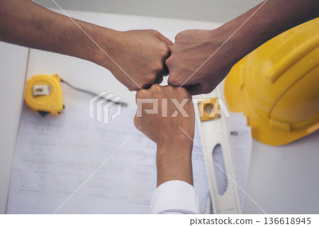 Close up engineer men hands diversity multiethnic partners team together. Group of multiracial people Engineer Manager Foreman Teamwork meeting join hands. Top view office table team join partnership Close up engineer men hands diversity multiethnic partners team together. Group of multiracial people Engineer Manager Foreman Teamwork meeting join hands. Top view office table team join partnership 136618945