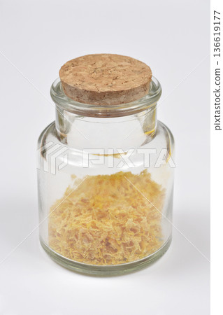 Grated dried lemon peel in a small glass jar with cork Grated dried lemon peel in a small glass jar with cork 136619177