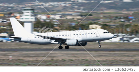 White transport plane takes off. Take-off on the runway. Panning shot, background becomes blurred White transport plane takes off. Take-off on the runway. Panning shot, background becomes blurred 136620453