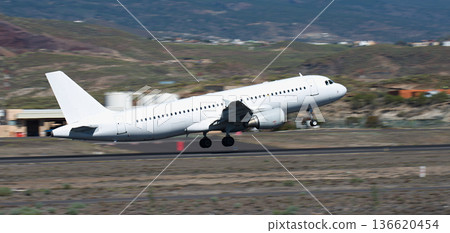 White transport plane takes off. Take-off on the runway. Panning shot, background becomes blurred White transport plane takes off. Take-off on the runway. Panning shot, background becomes blurred 136620454